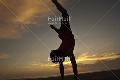 Fair Trade Photo Activity, Backlit, Beach, Colour image, Doing handstand, Emotions, Happiness, Horizontal, One boy, Outdoor, People, Peru, Portrait fullbody, Silhouette, South America, Sunset