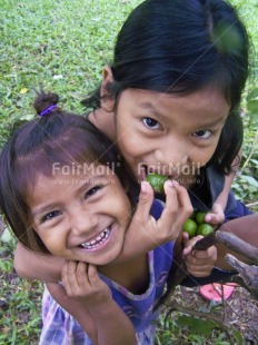 Fair Trade Photo Activity, Colour image, Eating, Emotions, Friendship, Happiness, Hug, Looking at camera, Love, Multi-coloured, Outdoor, People, Peru, Portrait headshot, Smile, Smiling, South America, Together, Two children, Two girls, Vertical