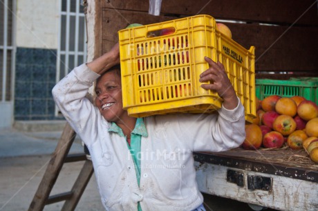 Fair Trade Photo Activity, Carrying, Colour image, Day, Entrepreneurship, Food and alimentation, Fruits, Horizontal, Latin, Mango, Market, One woman, Outdoor, People, Peru, Rural, Smiling, South America, Strength