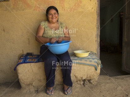 Fair Trade Photo Activity, Agriculture, Casual clothing, Clothing, Colour image, Dailylife, Day, Farmer, Horizontal, House, Looking away, One woman, Outdoor, People, Peru, Portrait fullbody, Rural, Sitting, Smiling, South America, Street, Streetlife