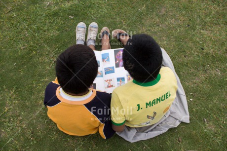 Fair Trade Photo 5 -10 years, Book, Casual clothing, Clothing, Colour image, Day, Education, Friendship, Grass, Latin, Outdoor, People, Peru, Reading, South America, Together, Two boys