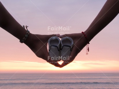 Fair Trade Photo Baby, Colour image, Couple, Hands, Holding, Horizontal, Love, New baby, Ocean, Outdoor, People, Peru, Sea, Shoe, South America, Sunset, Two