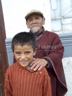 Fair Trade Photo Activity, Care, Clothing, Colour image, Dailylife, Family, Looking at camera, Multi-coloured, Old age, One boy, One child, One man, Outdoor, People, Peru, Poncho, Portrait halfbody, South America, Together, Traditional clothing, Vertical, Young