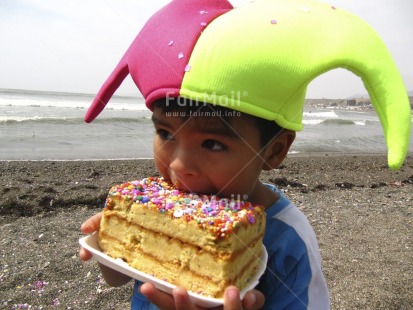 Fair Trade Photo Activity, Beach, Birthday, Cake, Clothing, Colour image, Colourful, Congratulations, Eating, Food and alimentation, Green, Hat, Horizontal, Looking away, One boy, Outdoor, Party, People, Peru, Pink, Portrait halfbody, Sand, Sea, South America