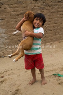 Fair Trade Photo Activity, Animals, Colour image, Dog, Emotions, Happiness, One boy, One child, Outdoor, People, Peru, Playing, South America, Vertical