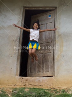Fair Trade Photo Activity, Colour image, Door, Emotions, Happiness, House, Jumping, Looking at camera, One girl, People, Peru, Rural, Smiling, South America, Vertical