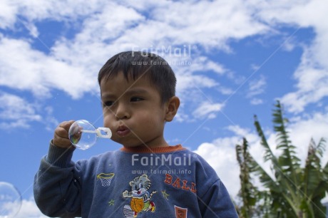 Fair Trade Photo Activity, Casual clothing, Clothing, Clouds, Colour image, Day, Horizontal, Looking away, One boy, Outdoor, People, Peru, Playing, Portrait halfbody, Rural, Seasons, Sky, Soapbubble, South America, Summer, Young