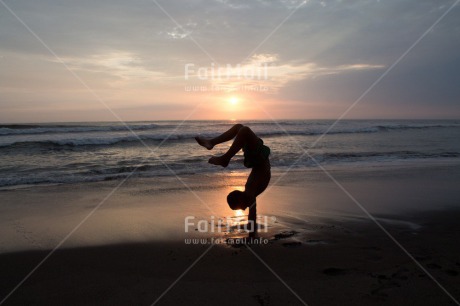 Fair Trade Photo 10-15 years, Activity, Backlit, Beach, Colour image, Doing handstand, Evening, Horizontal, One boy, Outdoor, People, Peru, Sea, Silhouette, South America, Sunset, Water, Yoga