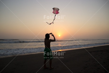 Fair Trade Photo 5 -10 years, Activity, Backlit, Beach, Colour image, Emotions, Evening, Freedom, Happiness, Kite, One boy, Outdoor, People, Peru, Playing, Sea, Silhouette, Sky, South America