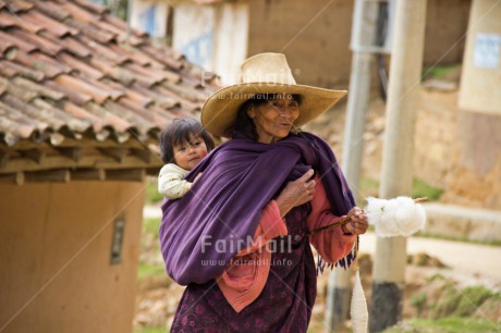 Fair Trade Photo Activity, Carrying, Colour image, Horizontal, Latin, Old age, One baby, One woman, Outdoor, People, Peru, Rural, Smiling, Sombrero, South America, Walking, Wool