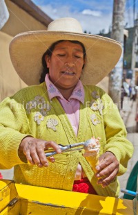Fair Trade Photo Activity, Colour image, Day, Entrepreneurship, Food and alimentation, Ice cream, Latin, Looking away, One woman, Outdoor, People, Peru, Portrait halfbody, Rural, Selling, Smiling, South America, Summer, Vertical, Yellow