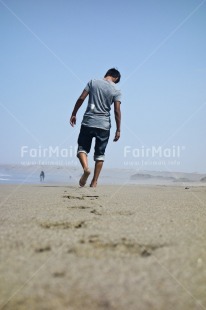 Fair Trade Photo 10-15 years, Activity, Barefeet, Beach, Casual clothing, Clothing, Colour image, Emotions, Looking away, One boy, People, Peru, Portrait fullbody, Sand, Sea, Seasons, Sky, South America, Summer, Vertical, Walking