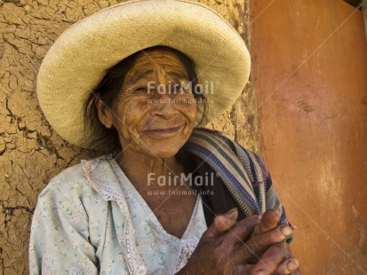 Fair Trade Photo 55-60 years, Activity, Agriculture, Clothing, Colour image, Day, Farmer, Hat, Horizontal, Looking at camera, Old age, One woman, Outdoor, People, Peru, Portrait headshot, Rural, Sitting, Smile, Smiling, Sombrero, South America, Street, Streetlife
