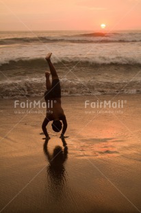 Fair Trade Photo Activity, Backlit, Beach, Colour image, Doing handstand, Evening, One boy, Outdoor, People, Peru, Reflection, Sea, Silhouette, South America, Spirituality, Sport, Sun, Sunset, Vertical, Yoga